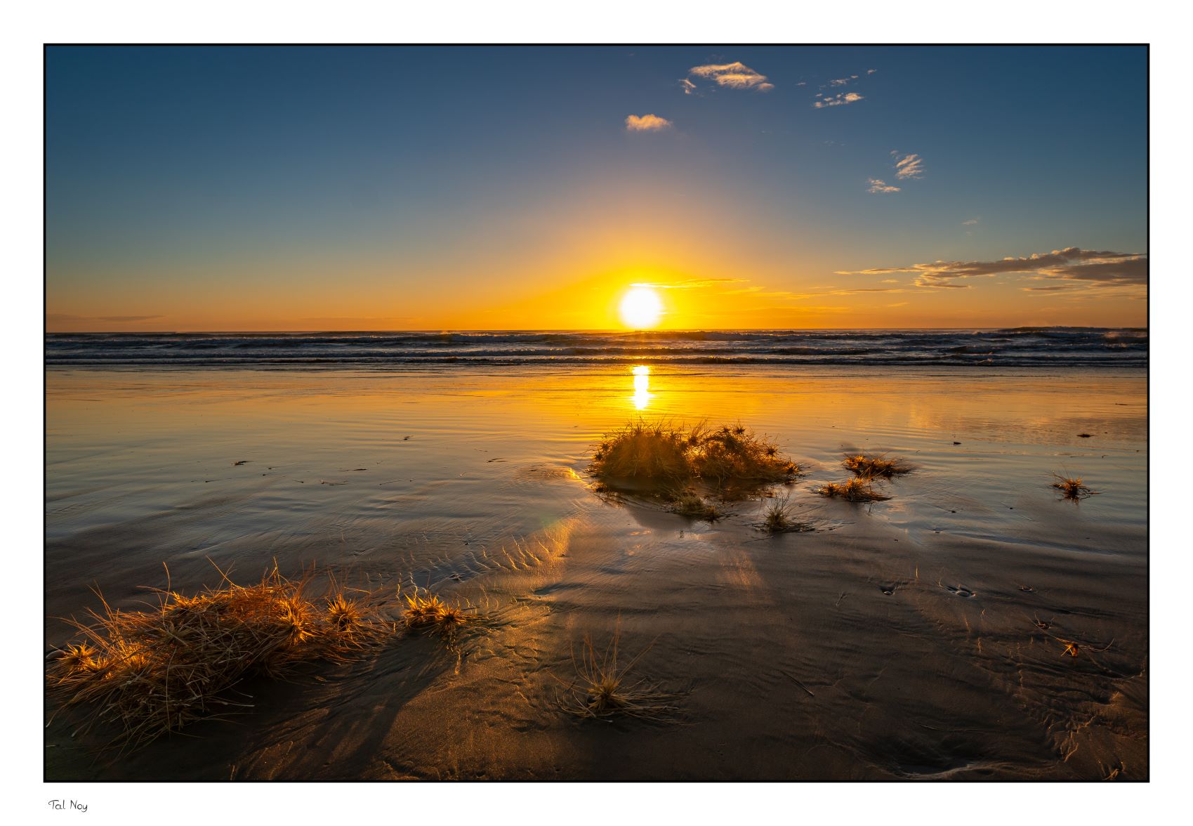 Sunset - golden light over a calm lake with silhouetted mountains